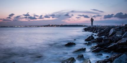 Lighthouse in distance passed rocks