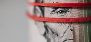 pic of Abe Lincoln money roll with red rubber band around it